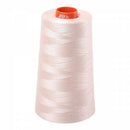 Cone of Aurifil Cotton thread that is sand coloured.